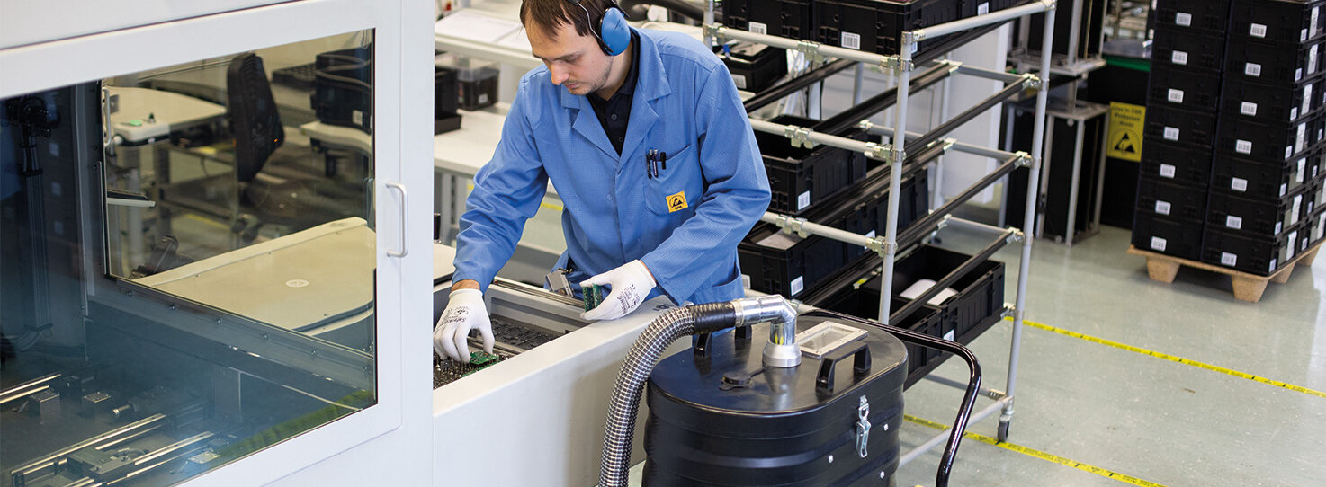 Průmyslový vysavač Ruwac R01 vysává prach z obvodových desek u firmy Schmersal ve Wuppertalu.